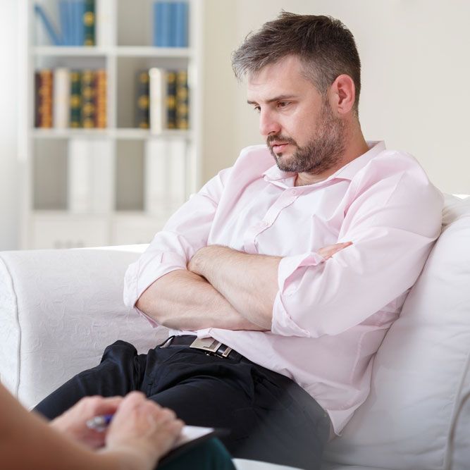 Addicted businessman talking with psychiatrist on psychotherapy session