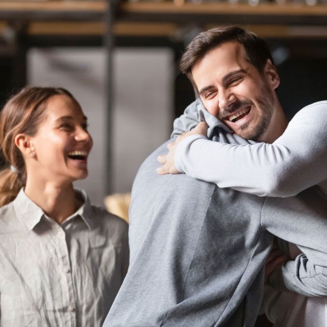 Happy diverse male buddies embracing greeting in cafe