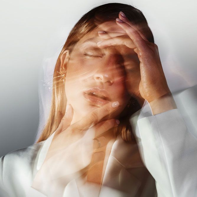 A young stylish woman in a white jacket, distortions of the model's face on a long exposure.