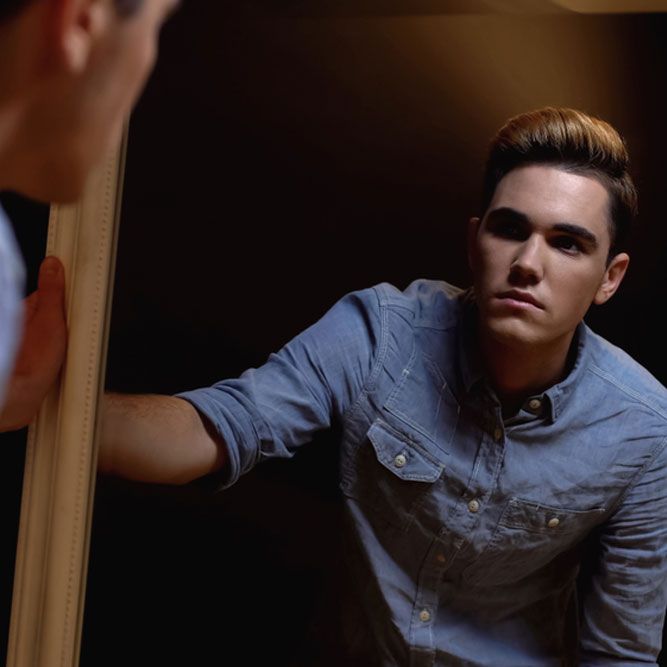 Transgender man looking in mirror, feels ugly or weird being male, insecurities