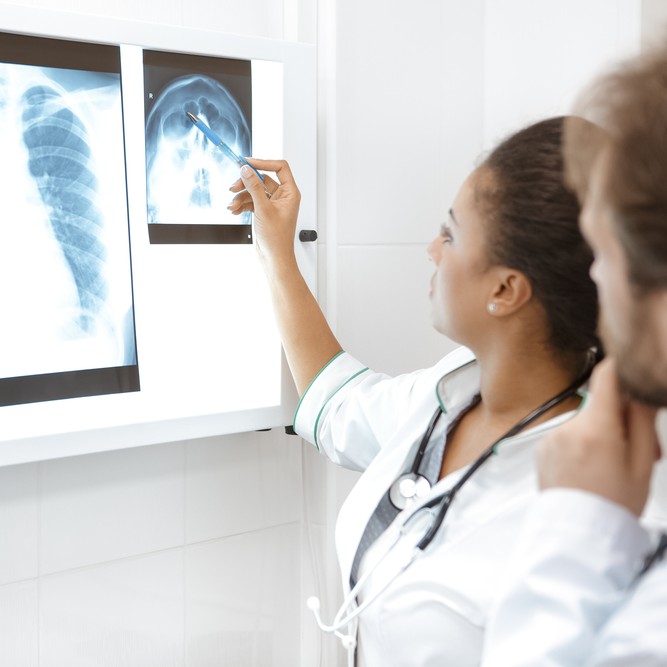 Paying attention to details. Shot of two doctors examining x-ray scans togethe