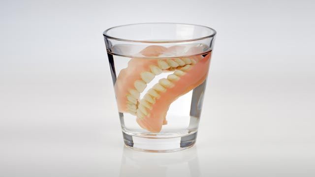 Old dentures in a glass of water.