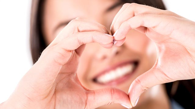 Woman making a heart shape with her hands - isolated over white