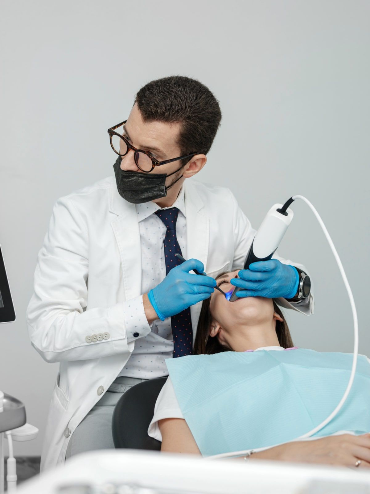 Male orthodontist scaning patient with dental intraoral scanner