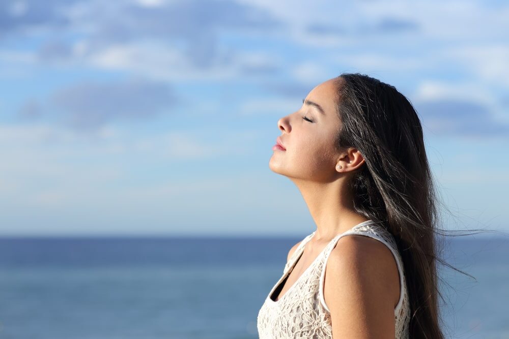 beautiful woman breathing fresh air in the beach