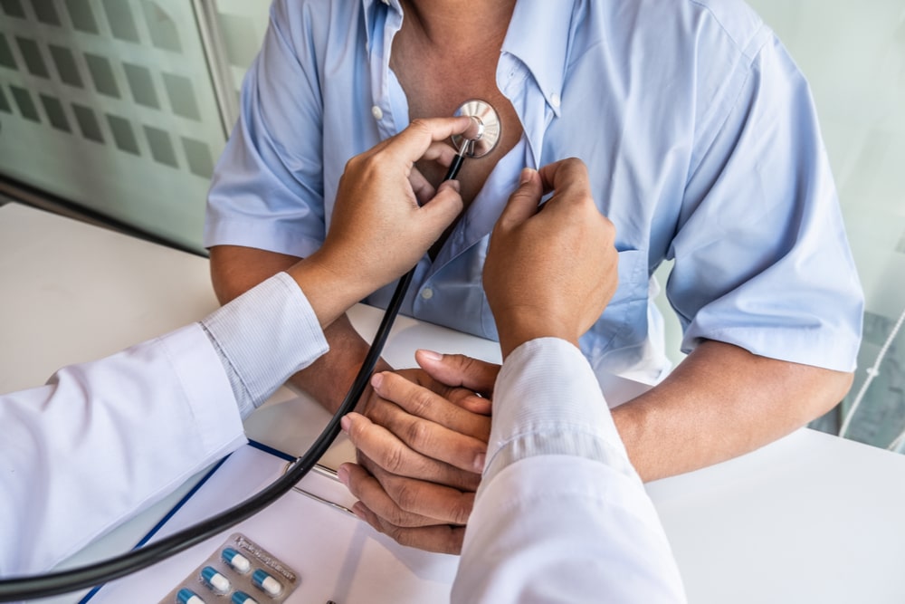 Male doctors perform a pulse test using a stethoscope