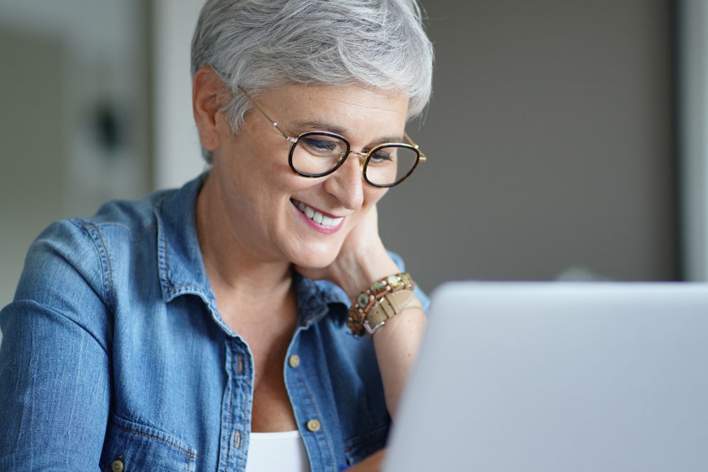 beautiful old woman with white hair working from home