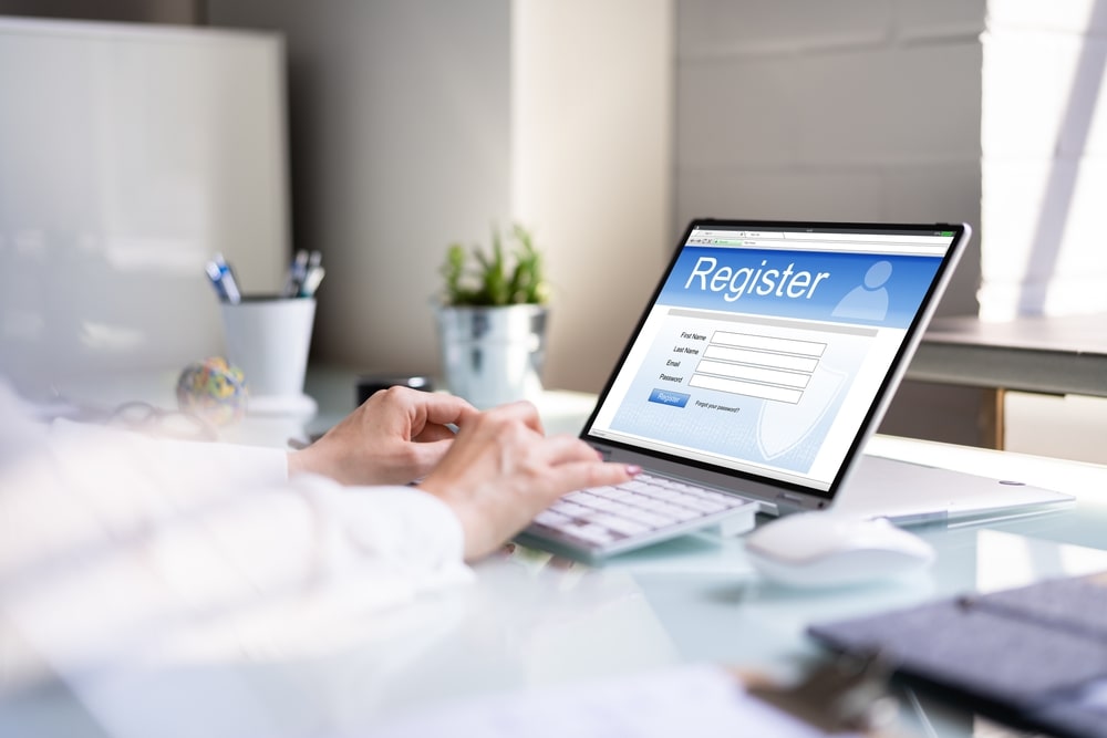 woman's Hand Filling Online Registration Form On Laptop