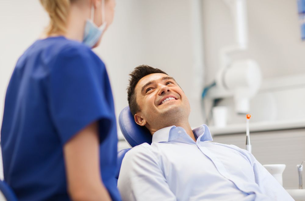 Female Dentist With Happy Male Patient