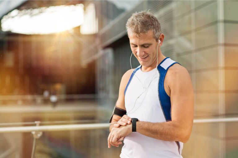 Portrait Of Happy Mature Man With Heart Rate Monitor On Wrist