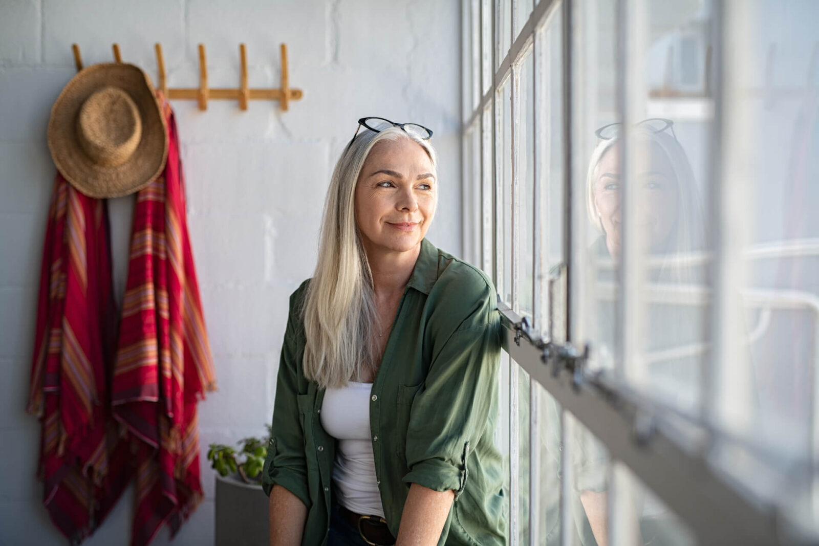 Smiling mature woman looking outside window.