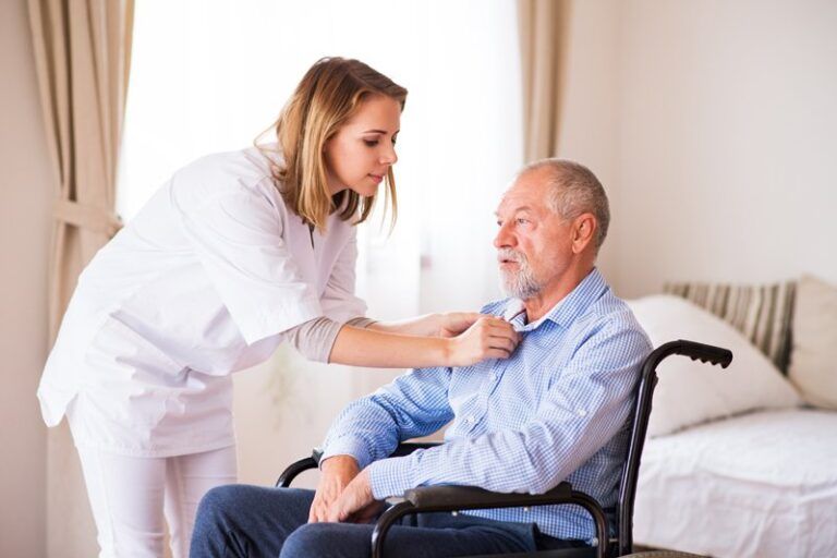 Nurse and senior man in wheelchair during home visit