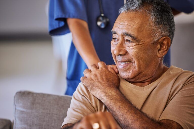Caregiver holding hand of her senior patient