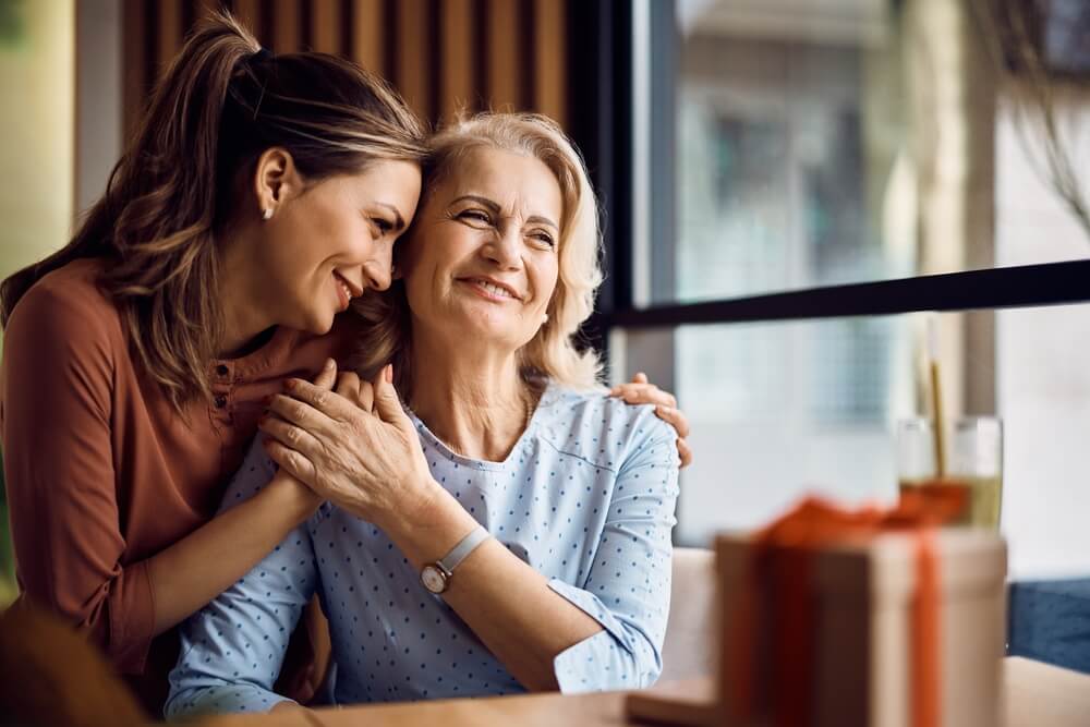 Happy senior woman enjoying in daughter's affection on Mother's day.