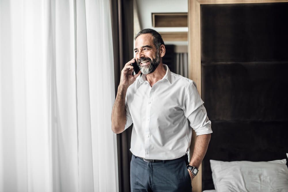 Handsome Caucasian middle-aged businessman standing at bedroom