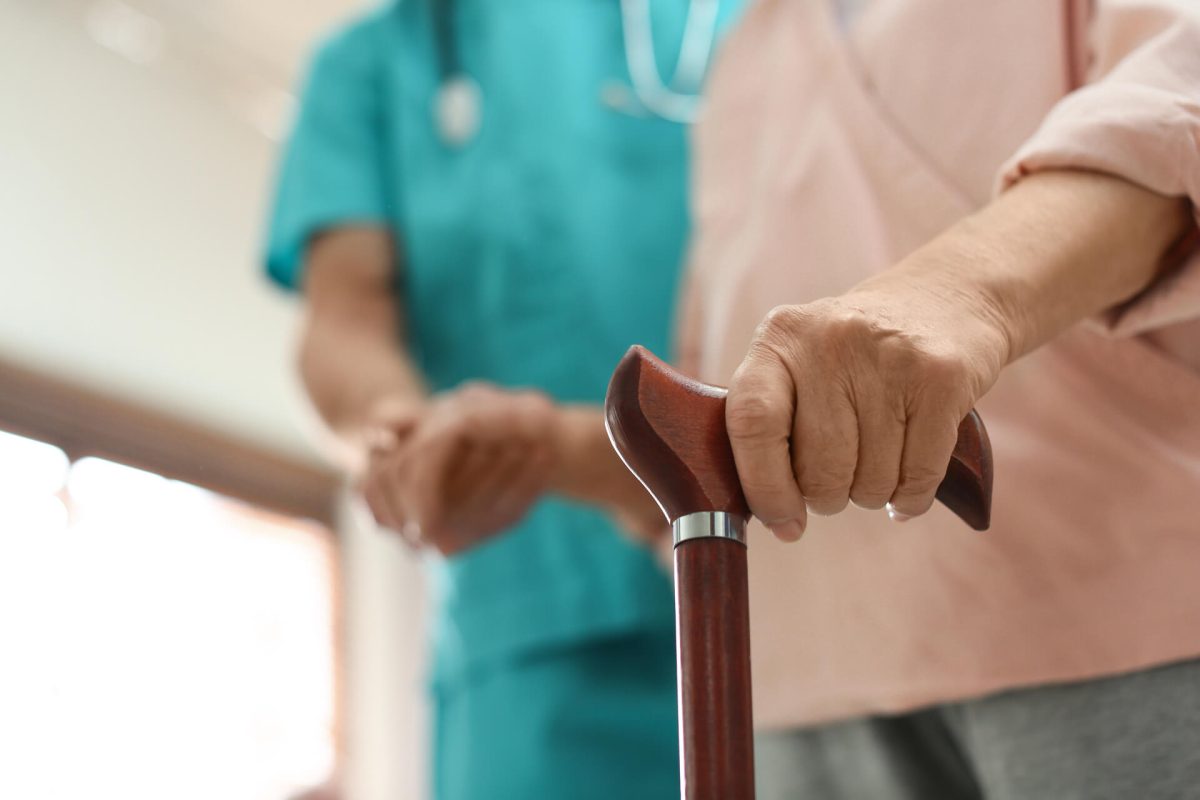 Medical worker taking care of elderly woman in geriatric hospice