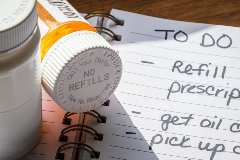 Medication bottles laying next to notebook