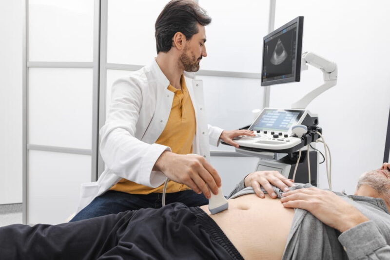 Ultrasound of prostate gland. Mature man getting ultrasound of prostate gland with sonography specialist using ultrasound sensor