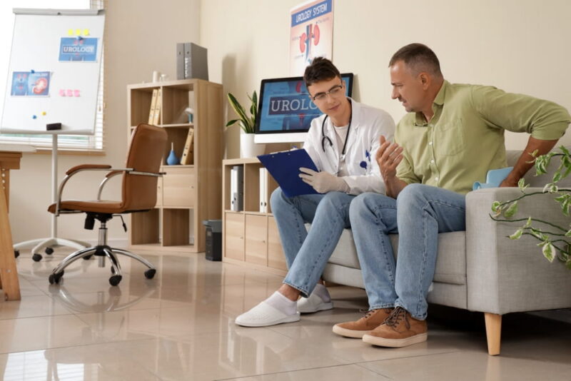 male patient is with male doctor discussing pain