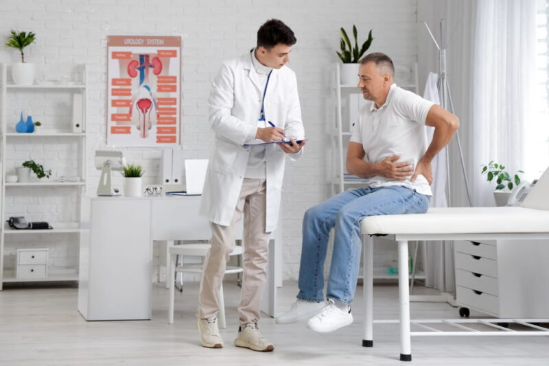 urologist working with man on couch in office