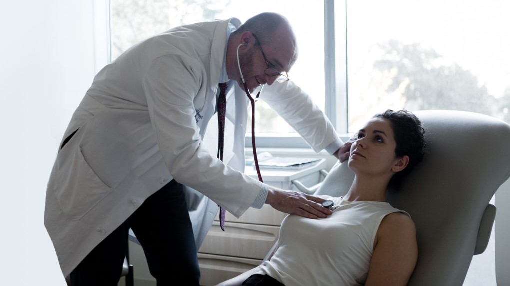 Doctor examining patient with stethoscope