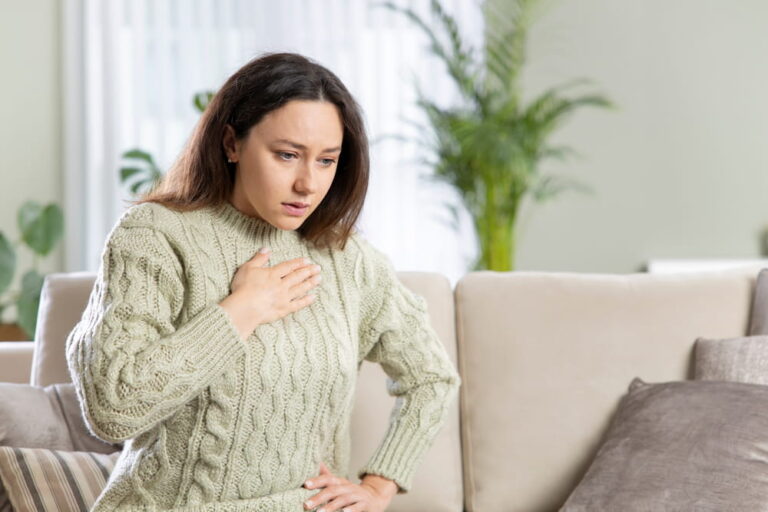 Stressed woman is suffering from a chest pain. Pressure in the chest.