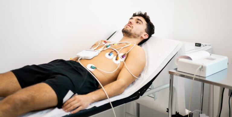 A young man undergoes an electrocardiogram test to diagnose heart disease in a hospital ward. electrocardiograph