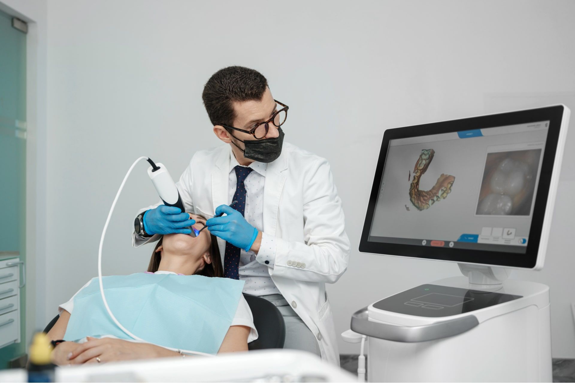 Male orthodontist scaning patient with dental intraoral scanner