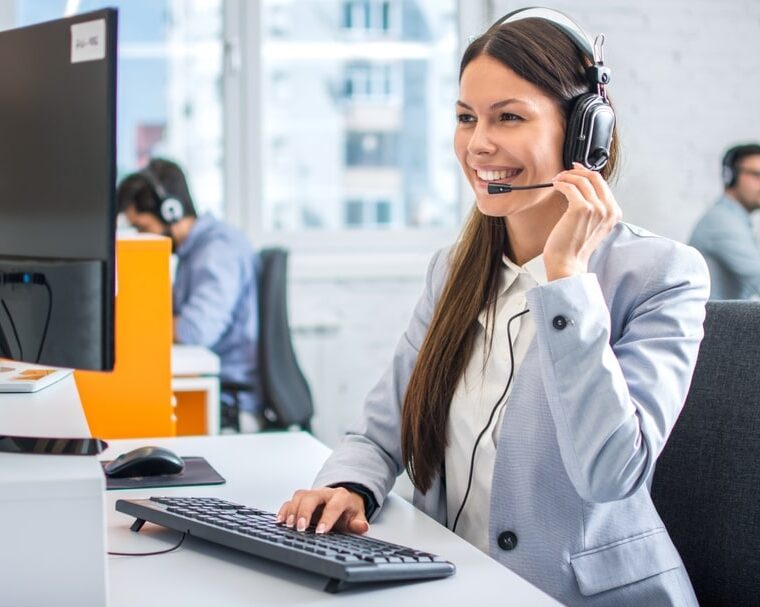 Friendly female helpline operator in call center.