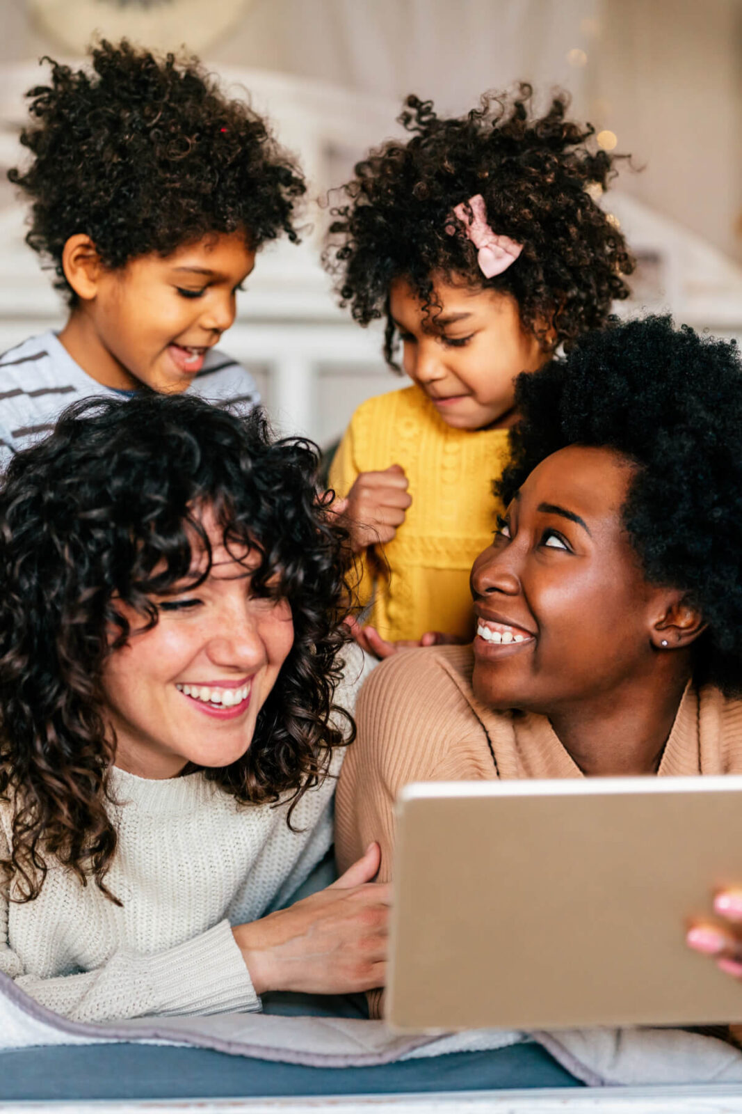 Happy multiethnic women couple having fun with kids