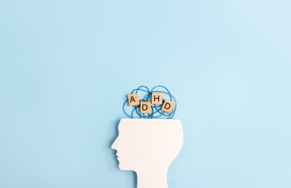 Silhouette of human head and wooden blocks with the letters ADHD