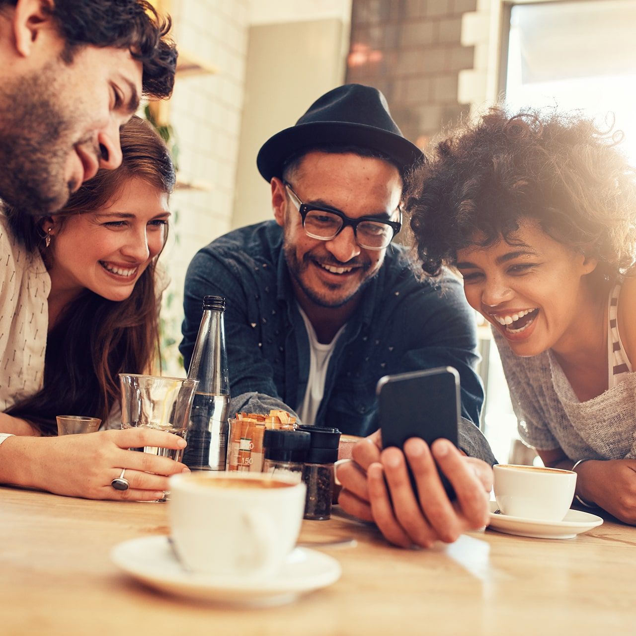 Portrait of cheerful young friends looking at smart phone