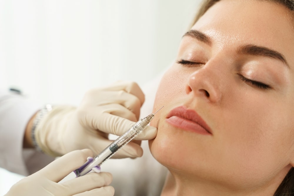 Woman patient getting lip filler injection