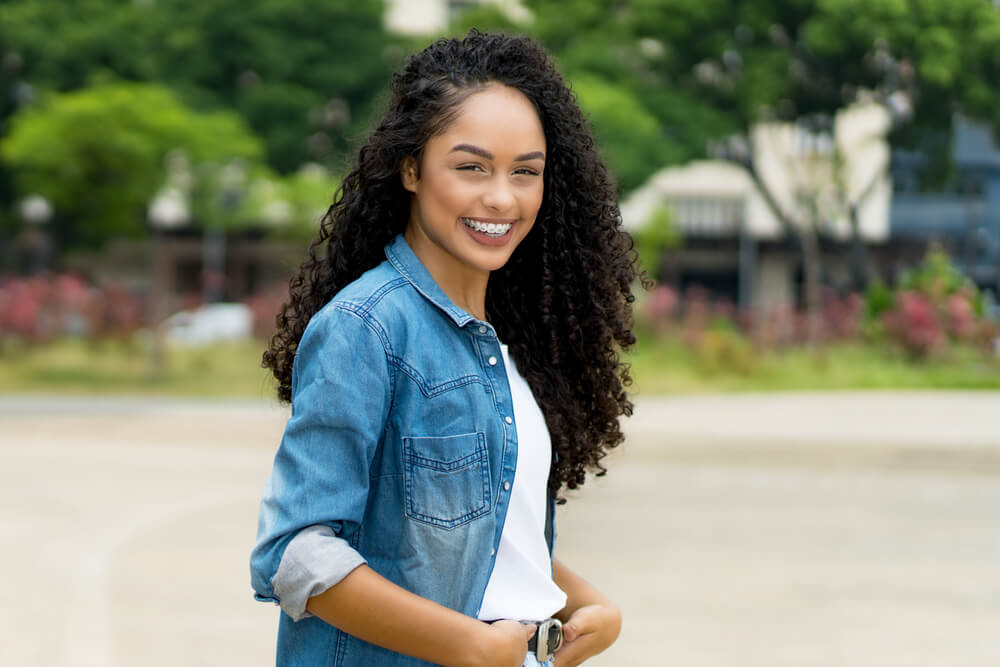 young adult woman with retainer outdoor in summer