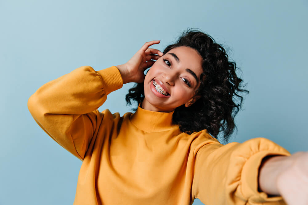 Girl in dental braces taking selfie