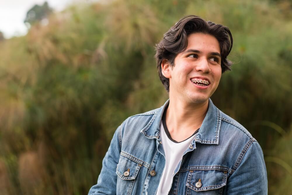 young man with acne confident, smiling