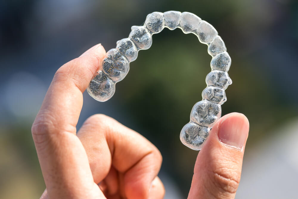 Holding invisalign braces on bokeh background