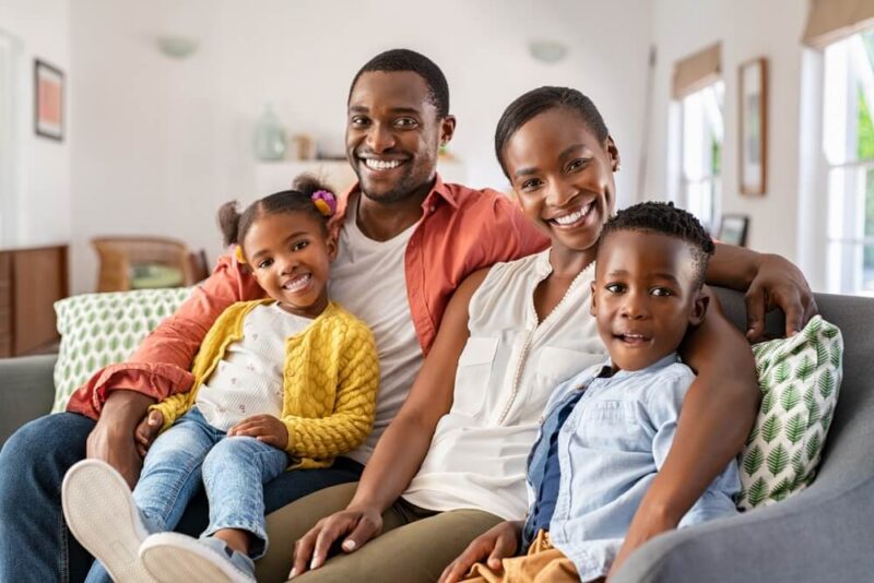 Happy couple with son and daughter relaxing on sofa