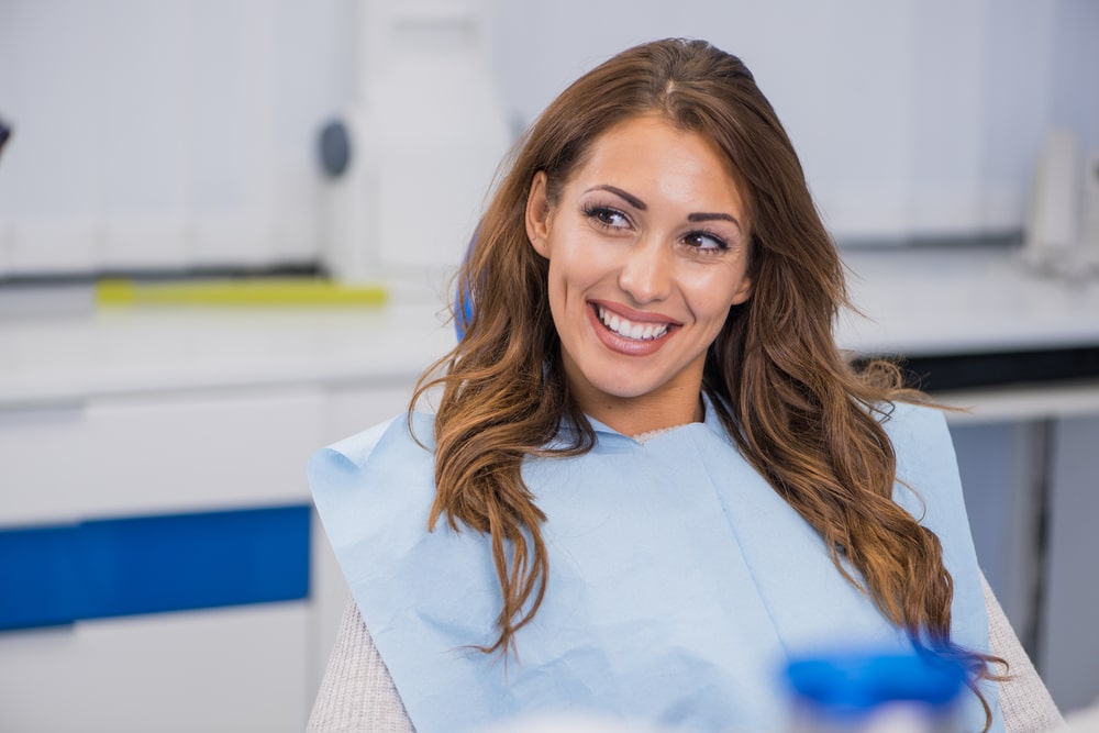 Smiling Dentist and Patient in Dental Clinic