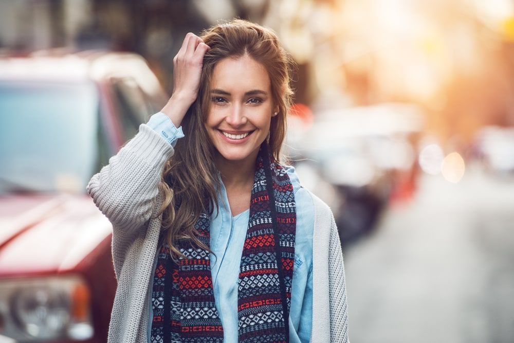 Happy young adult woman smiling with teeth smile outdoors