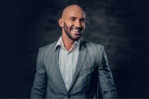 Positive shaved head male dressed in a grey suit