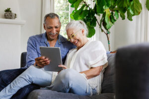 Elderly couple using a tablet on a couch