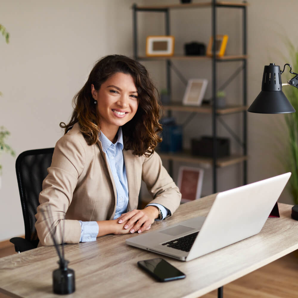 Portrait of a young business woman sitting at a desk in the office