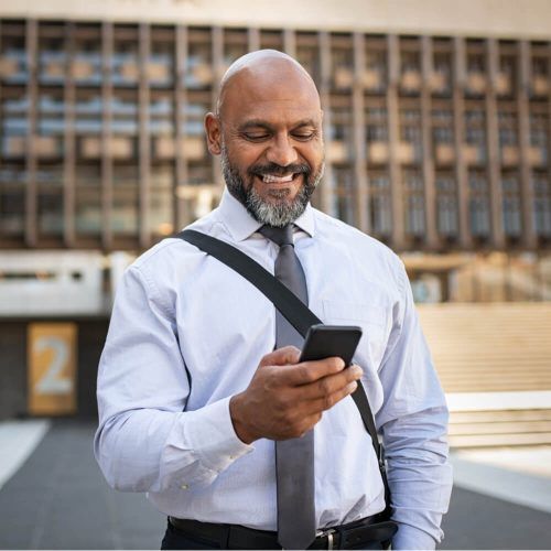Happy african businessman holding mobile phone