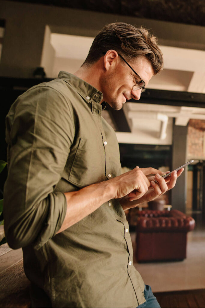 Side view of handsome young man reading text message