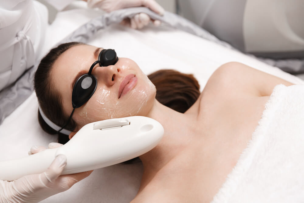 Smiling woman enjoying ELOS skin rejuvenation facial