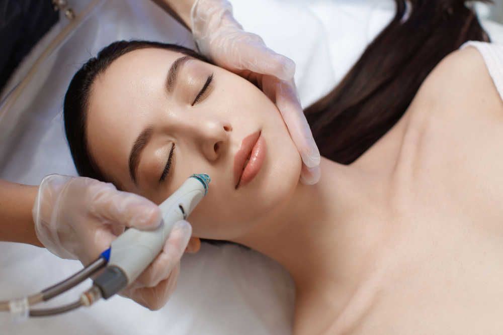 Professional female cosmetologist doing hydrafacial procedure in Cosmetology clinic