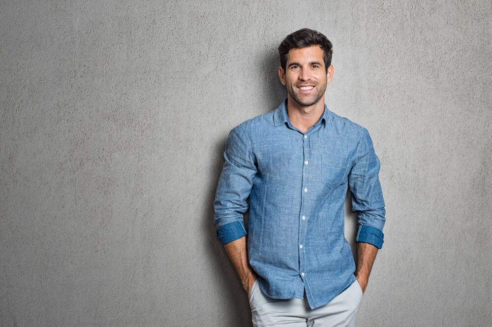 handsome man smiling against grey background