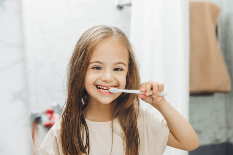 Portrait of a girl with Down syndrome brushing her teeth