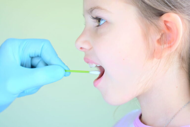 pediatrician using a cotton swab to take a sample from a girl throat
